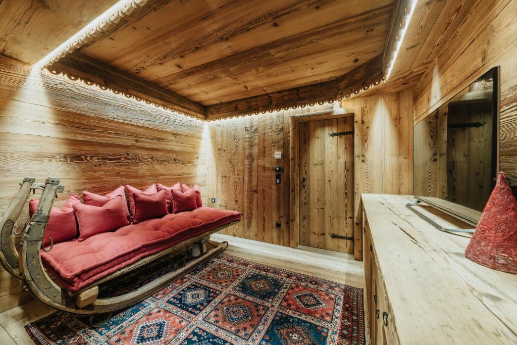 Casa Aurea, Cortina d'Ampezzo — reading lounge with backlit timber ceiling and red cushions