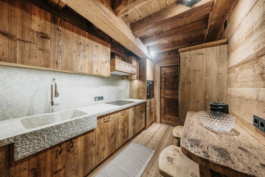 Casa Aurea, Cortina d'Ampezzo — kitchen with carved stone sink and timber worktop