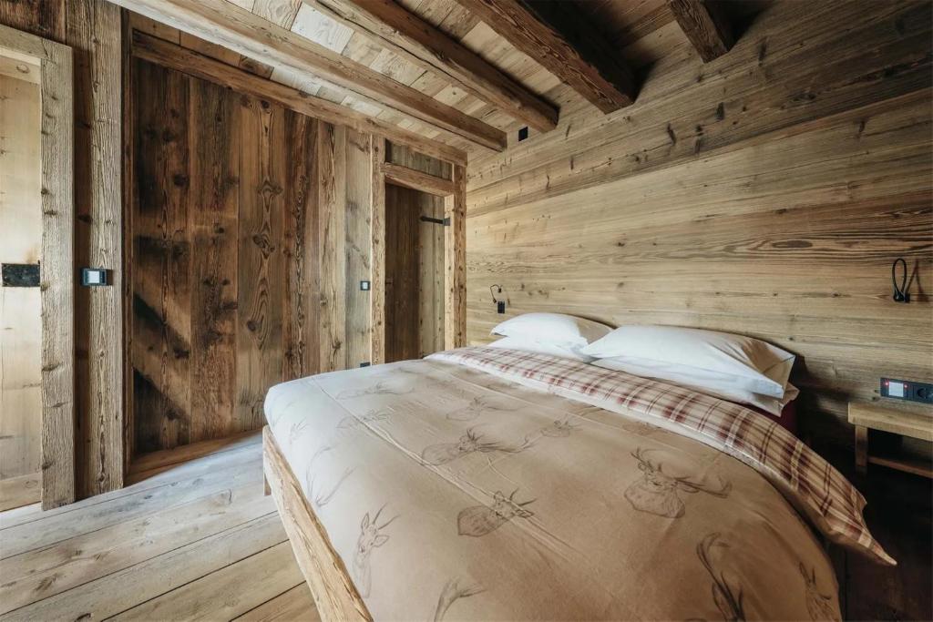 Casa Aurea, Cortina d'Ampezzo — master bedroom in aged Alpine timber