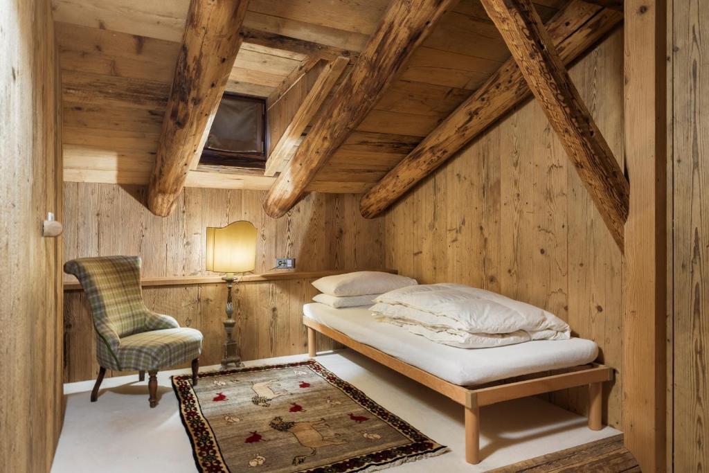 Casa Aurea, Cortina d'Ampezzo — bedroom with armchair and Persian rug