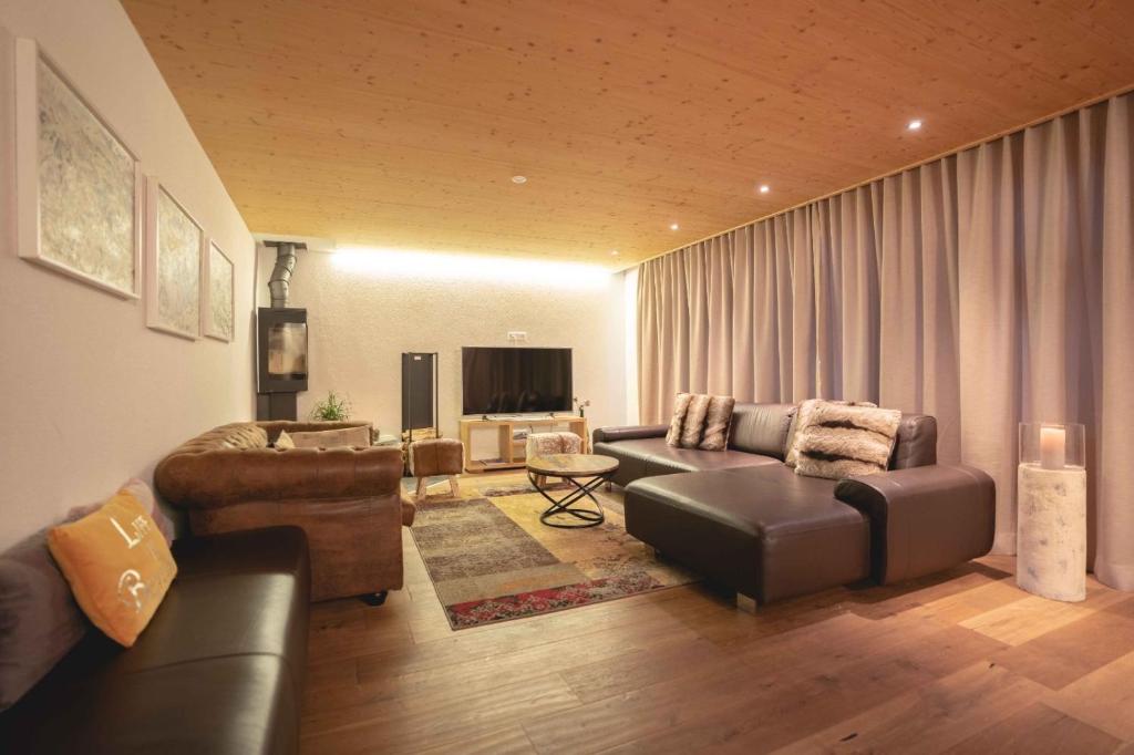 Chalet Talisman, Zermatt — living room with leather sofas and wood-burning stove